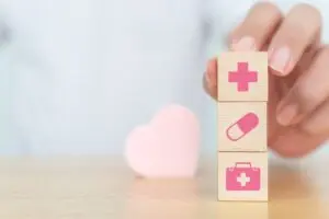 Wooden block cubes with shapes on wood table for healthcare icon 