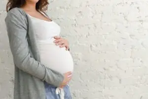 Pregnant woman touching belly.