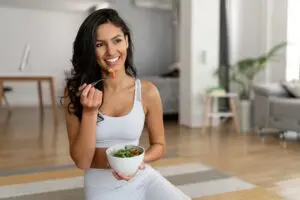 Woman eating healthy food after workout. 