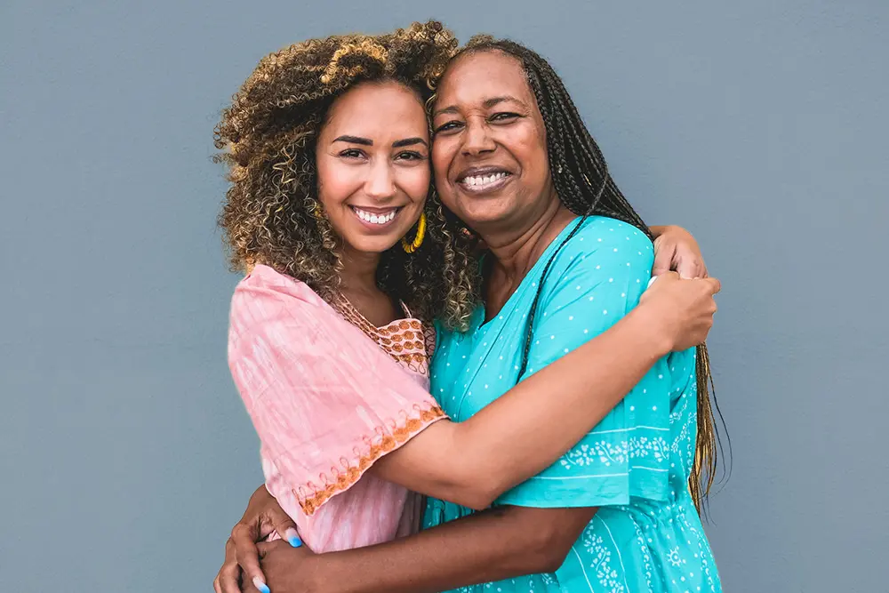 Portrait of cheerful african mother and adult daughter together